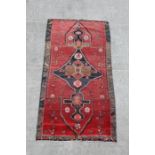 A Persian Hamadan woollen hand knotted rug with stylised birds and animals within borders, on a