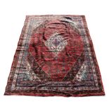A Persian Hamadan woollen hand knotted carpet with foliate design on a red ground, 350 by 250cms (