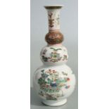 A Chinese Kangxi famille rose triple gourd vase decorated with precious objects, 26cms high.