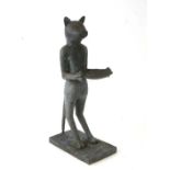A patenated brass / bronze figure of a standing cat holding a shallow bowl, 50cms high.