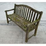 An Alexander Rose well weathered teak garden bench, 149cms wide.