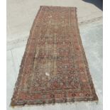 A Persian Kellah runner with repeating geometric pattern on a red ground, 472 by 174cms.