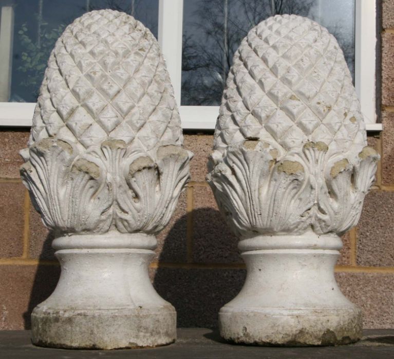 A pair of well weathered painted reconstituted stone pineapple finials, 60cms high (2).