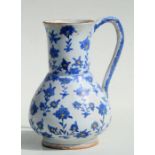 A Turkish / Iznik water jug decorated with flowers, 23cms high.