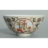 A Chinese famille rose bowl decorated with precious objects within roundels and foliate scrolls, red