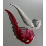 A Nailsea style glass pipe, 34cms long; together with a similar cranberry glass pipe, 37cms long (