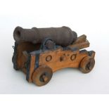 A cast iron signal cannon, possibly 18th century, on a later wooden carriage, 32cms long.
