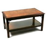 A walnut & mahogany two-tier coffee table, each tier inset with a tooled leather panel, 68cms wide.
