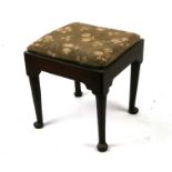 An early 19th century mahogany stool with drop-in upholstered seat, on turned legs and pad feet,