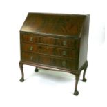 An Edwardian figured mahogany bureau, the fall-flap enclosing a fitted interior above three