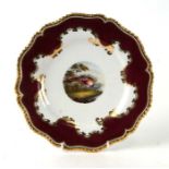 A Flight Barr Barr Worcester plate with central painted bird within a purple and gilt border,