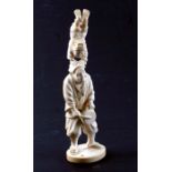 A 19th century Japanese ivory okimono depicting a musician and a young boy acrobat, three