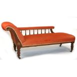 An Edwardian walnut chaise longue with upholstered arm and seat, 73cms long.