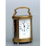 A brass cased carriage time piece, the white enamel dial with Roman numerals, 13cms high.