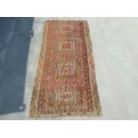 A kilim rug with repeating geometric motifs on a mustard ground within a multi border, 152 by