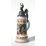 A German pottery stein with pewter mounts decorated with a German regimental scene, 32cms high.