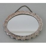 A Persian 900 grade silver oval wedding mirror with wavy rim and repousse decoration, 16cms wide.