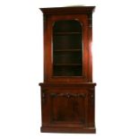 A Victorian figured mahogany bookcase on cupboard, the glazed upper section with shelved interior