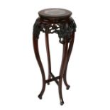 A Chinese hardwood plant stand with inset figured marble top and pierce prunus frieze.