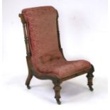 A 19th century upholstered walnut nursing chair on turned front supports.