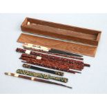 A group of lacquer and bone chopsticks in a hardwood case.
