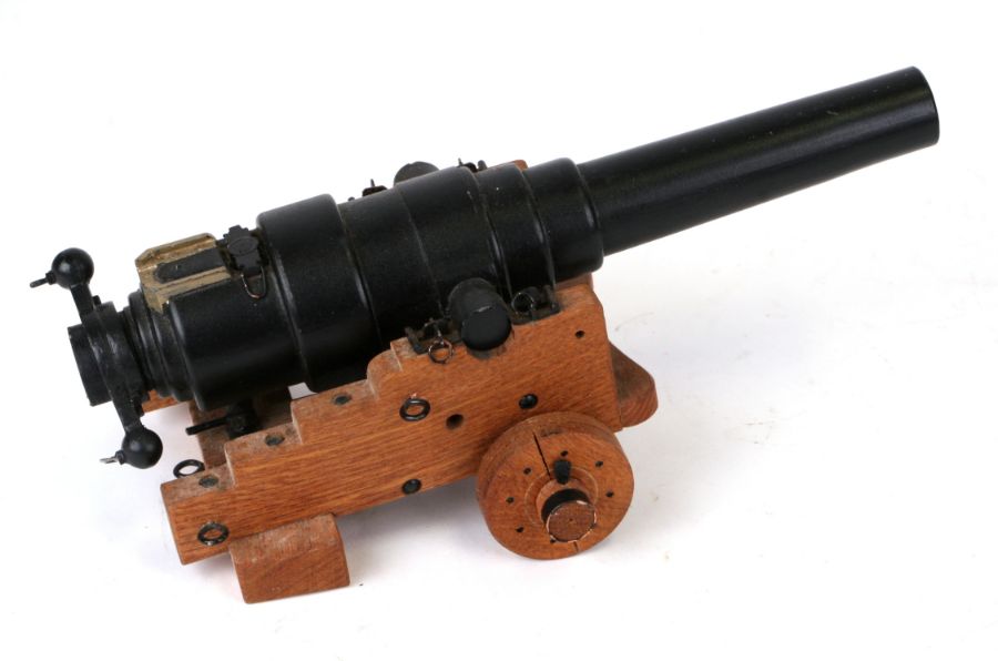 A cast iron miniature cannon on a wooden carriage, 28cms long.Condition ReportThis is a model, not