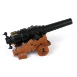 A cast iron miniature cannon on a wooden carriage, 28cms long.Condition ReportThis is a model, not