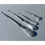 Four late Victorian silver handled button hooks, various dates and makers.