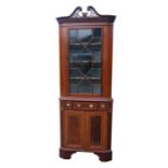 A 19th century mahogany corner display cabinet on cupboard, the upper section with a pierced swan