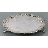 A silver plated salver with engraved foliate scrolls, on three legs, 36cms diameter.