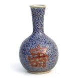 A Japanese pottery bottle vase decorated characters amongst scrolls on a blue ground with