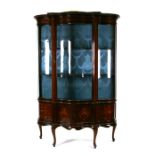 An Edwardian mahogany bowfront glazed display cabinet in the Sheraton taste, on dwarf cabriole legs,