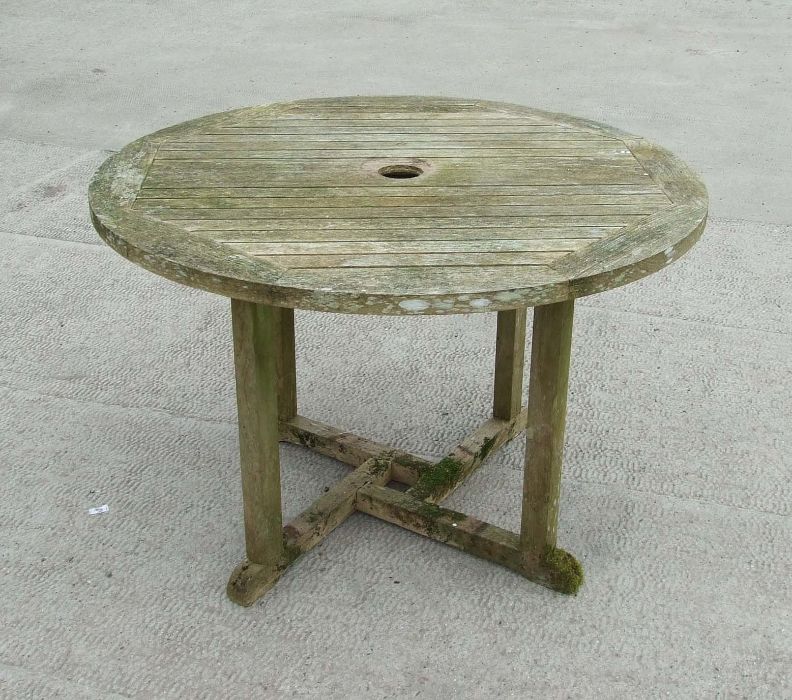 A well weathered teak circular garden table, 109cms diameter.