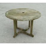 A well weathered teak circular garden table, 109cms diameter.