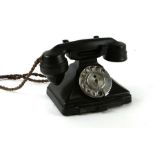 A Bakelite spin dial telephone.