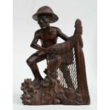 A large Asian hardwood carving depicting a fisherman with his net, 35cms high.