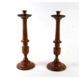 A pair of turned wooden candlesticks with brass drip pans, 40cms high (2).