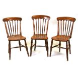 Three elm and fruitwood kitchen chairs on turned legs joined by a stretcher (3).Condition Reportgood