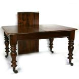 A Victorian mahogany extending dining table with one extra leaf, on turned legs with brass