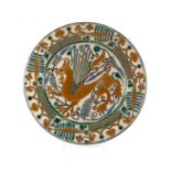 A continental Arts & Crafts style charger decorated with a stylised dragon within a foliate