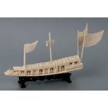 An early 20th century Chinese carved ivory ceremonial barge on a hardwood stand, 26cms long.