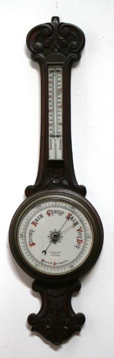 An Edwardian carved oak wheel barometer and thermometer, 25cms diameter.