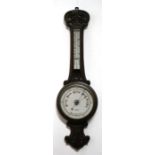 An Edwardian carved oak wheel barometer and thermometer, 25cms diameter.