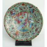 A Chinese Canton export famille rose charger decorated with figures in a court scene within a