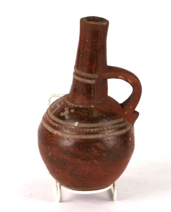 A North African pottery vessel of globular form with single handle and applied decoration, 20cms