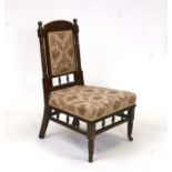 A Godwin design style walnut nursing chair with upholstered seat and back.