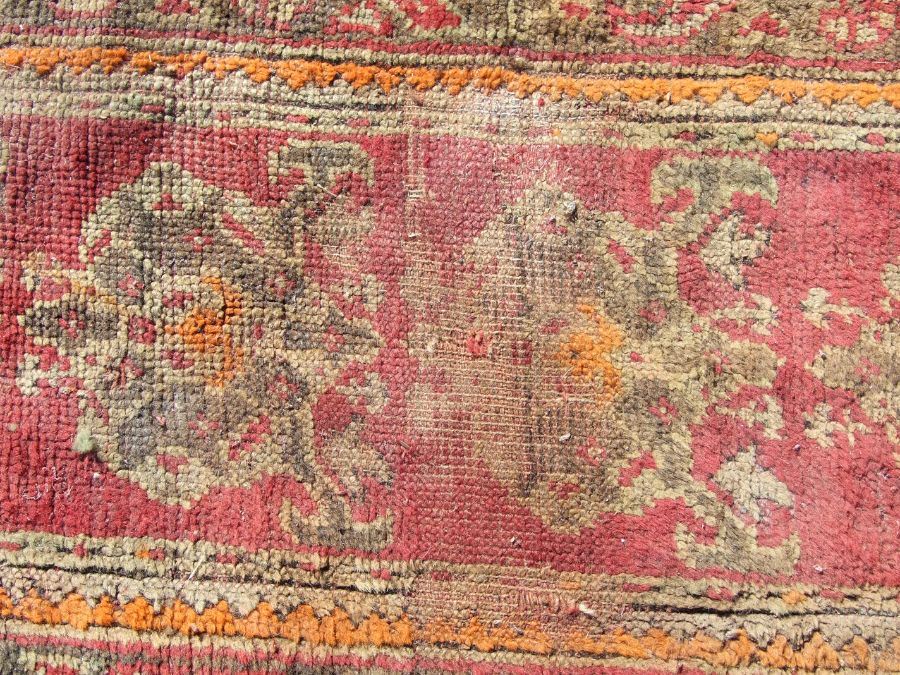 A Turkish runner with repeated floral decoration on a red ground, 392 by 73cms. - Image 2 of 6