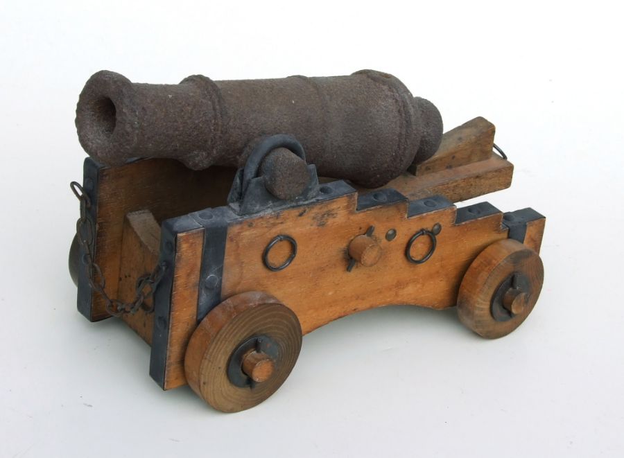 A cast iron signal cannon, possibly 18th century, on a later wooden carriage, 32cms long.