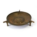 A continental Arts & Crafts brass bowl on three stylised legs, 31cms diameter.