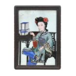 An antique Chinese reverse painting on glass depicting a robed seated woman with books on a table,